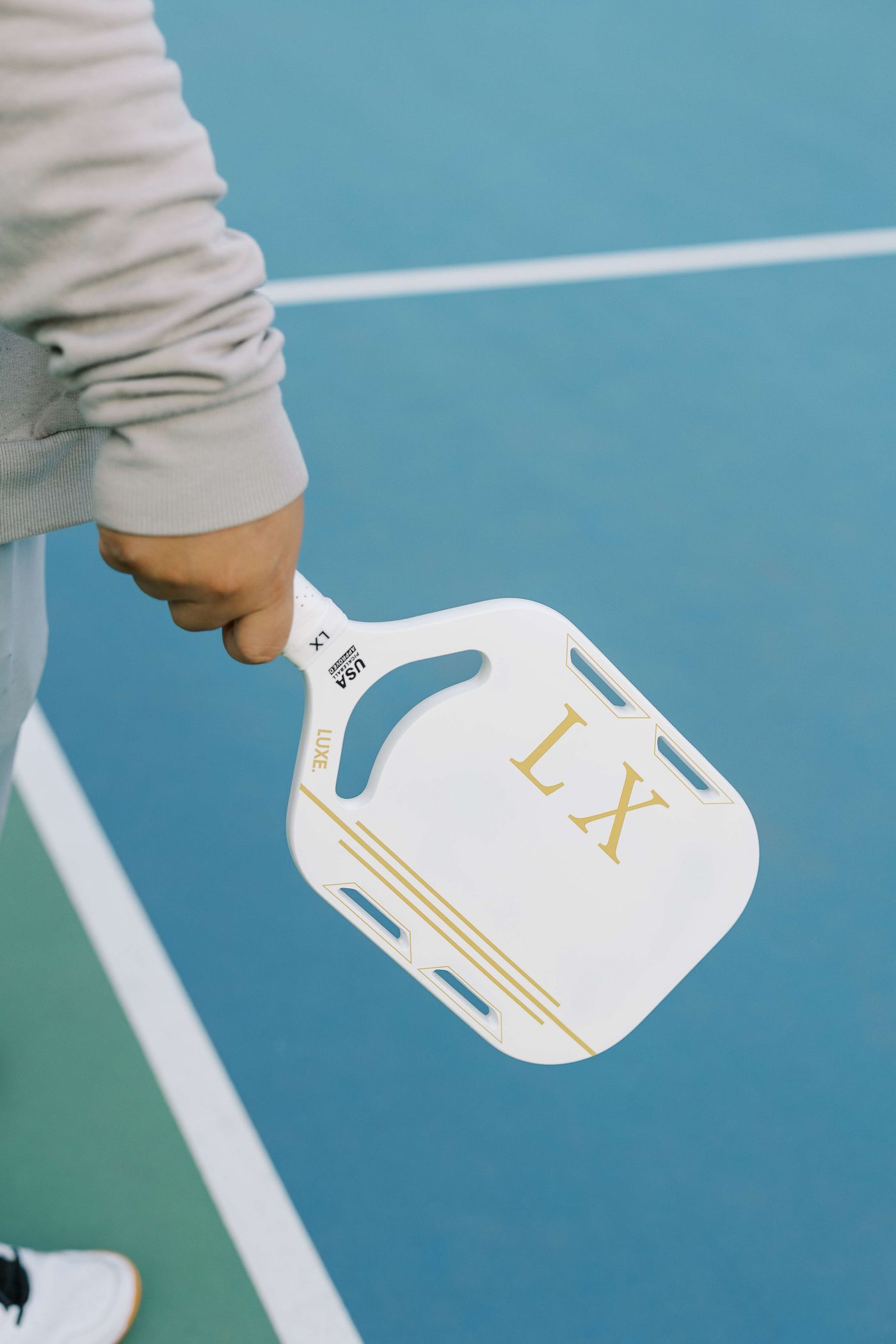 Pickleball paddle and ball on a court
