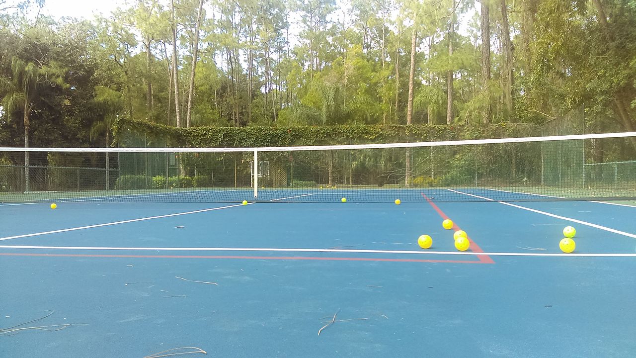 Yellow pickleballs on a court