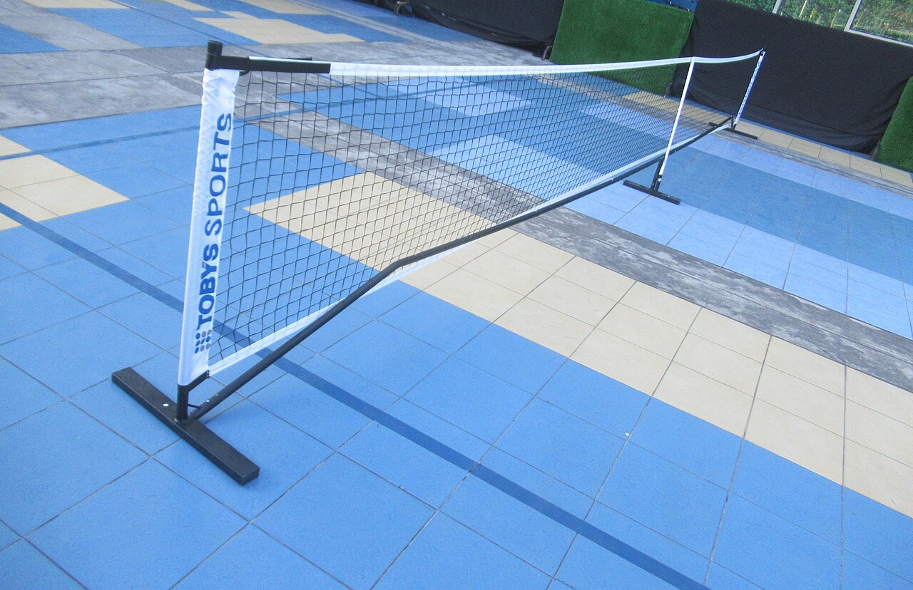 Outdoor blue pickleball court with brown nets